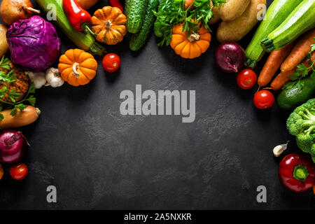 Contexte culinaire avec des légumes crus noire sur une table de cuisine, la nourriture végétarienne saine concept, mise à plat, vue de dessus de la composition Banque D'Images
