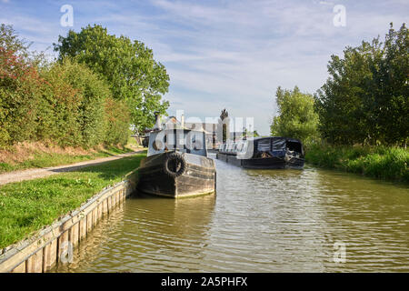 Un bateau à faisceau de fils traversant un bateau à narrowboat amarré montrant la largeur de ces bateaux et l'espace qu'ils occupent sur les cours d'eau. Banque D'Images