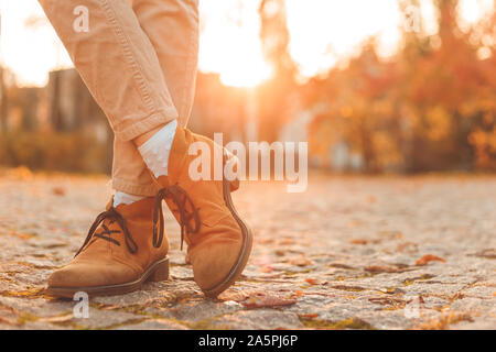 Les jambes des femmes dans d'élégantes Bottes nubuck d'automne. Au coucher du soleil dans la ville. Banque D'Images