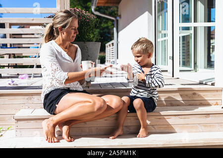 Mère avec son playing roche-papier-ciseaux Banque D'Images