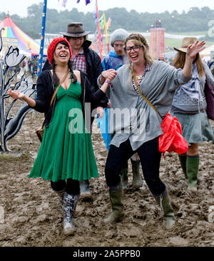 Les gens qui marchent dans un champ de boue Glastonbury Festival UK Banque D'Images