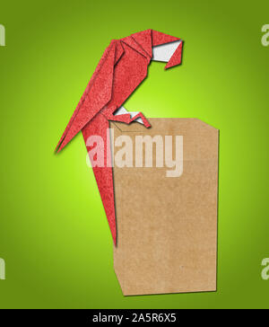 Perroquet origami en papier sur fond vert Banque D'Images