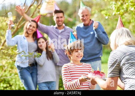 Enfant obtient un gâteau pour un anniversaire sur une partie de l'été Banque D'Images