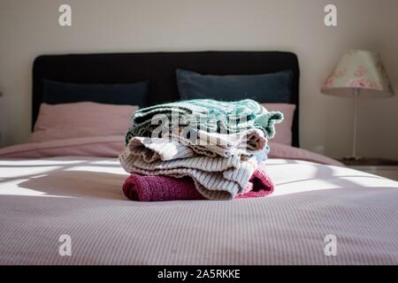 Soigneusement pliés winter fair isle pulls sur un lit dans une chambre à la maison Banque D'Images