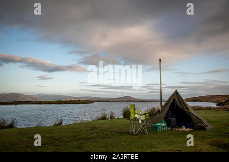 Wilding camping, tente avec poêle à bois à côté d'un lac de Brecon Beacons, Wales UK Banque D'Images