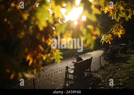 Les gens s'assoient sur des bancs dans St James's Park, Londres. Banque D'Images