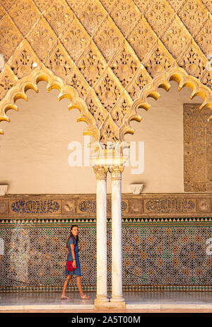 Une femme marche sous arcades du Patio de las palais Alcazar demoiselles de l'Alcazar de Séville Séville Royal Alcázar de Séville espagne andalousie Banque D'Images