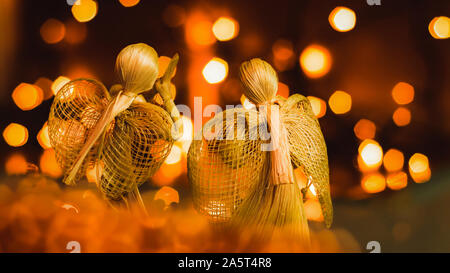 Deux anges priant de paille sur un fond de Noël floue. Beau bokeh créé par des lumières de Noël. Fait à la main traditionnelle poupée comme un tre de Noël Banque D'Images