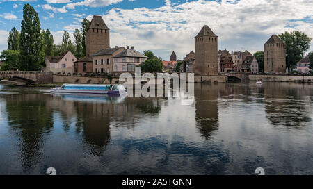 Strasbourg, Bas-Rhin / France - 10 août 2019 - vue sur la vieille ville et les canaux de Strasbourg avec un navire passant par Banque D'Images