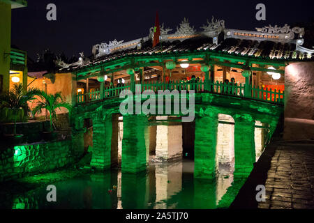 Le pont couvert japonais allumé en vert de lumière la nuit à Hoi An. Banque D'Images