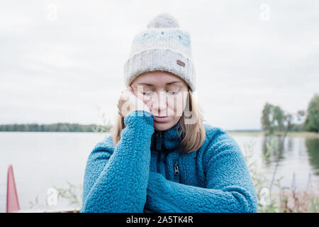 Femme à la triste et ennuyé tout en camping à l'extérieur à l'automne Banque D'Images