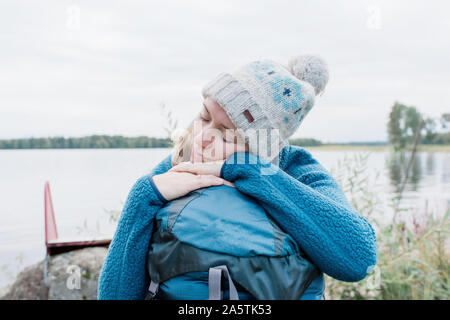 Femme dort sur son sac à dos tout en camping à l'extérieur à l'automne Banque D'Images