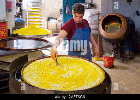 Garçon, un Knafeh préparation dessert traditionnel arabe faite avec la pâte de semoule avec du fromage en couches et imbibées de doux, à base de sucre d'érable. al-Aqsa des bonbons, Banque D'Images