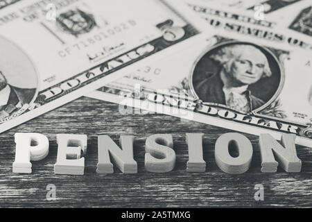 Macro photo noir et blanc avec le mot anglais -pension- en face de billets en dollar mat Banque D'Images