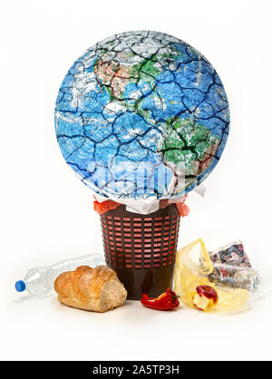 Image conceptuelle de détruire la planète. La planète Terre est jeté dans les ordures, l'alimentation, les déchets jetés,Corbeille, isolé sur un fond blanc. Banque D'Images