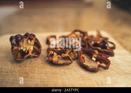 Le Habanero chocolat poivron (Capsicum chinense) tranches sur une planche à découper en bois. Et vraiment sain Hot Chili Peppers. Banque D'Images