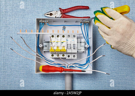 Unité de consommation ou CU sont remplacer pour de nouveaux depuis l'époque de l'ancien est en mauvais état. L'installation d'un coupe-circuit automatique sur un rail DIN. Un électricien secure Banque D'Images