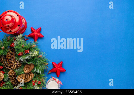 Mise à plat de Noël avec des branches de sapin composition décoration sur la surface bleue. Banque D'Images