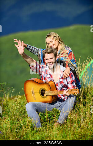 L'air frais et pur des sentiments. Petit ami et petite amie avec la guitare. Randonnées romantiques. Promenade romantique. Chanson romantique. L'amour qui les inspire. Beau couple romantique happy smiling faces fond nature. Banque D'Images