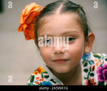 Merida, Yucatan, Mexique - 10 mai 2015 : Blue-eyed, 7 ans mexican girl wearing régionaux mayas Huipil (robe) et un tissu fleur sur ses cheveux. Banque D'Images