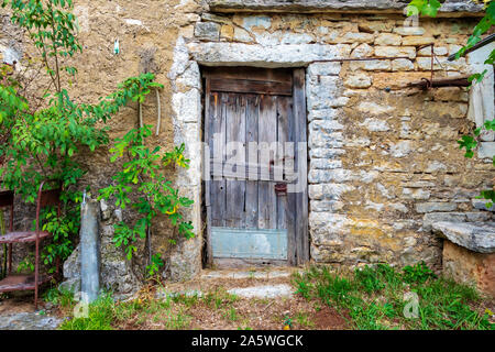 Vieille porte en bois verrouillée sur une pierre ferme abandonnée. Droit Banque D'Images