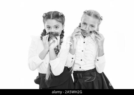 Style de fantaisie. Peu de filles avec des tresses, des prêts pour l'école. Concept de la mode de l'école. L'École de l'amitié. Sur la même vague. Usure uniforme de l'école formelle écolières. Les enfants belles filles de long cheveux tressés. Banque D'Images