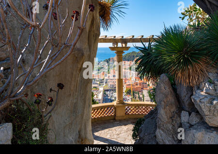 Vue sur la mer Méditerranée et la ville de Monte Carlo, Monaco, entre les colonnes de la terrasse à flanc de jardins exotiques. Banque D'Images
