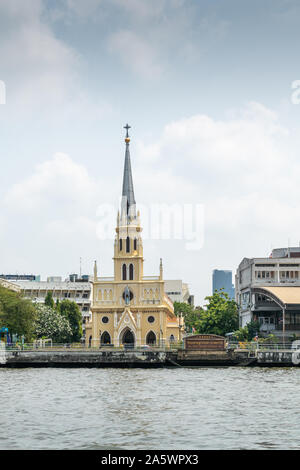 La ville de Bangkok, Thaïlande - le 17 mars 2019 : Chao Phraya. Vue frontale sur l'église Saint Rosaire peints en jaune avec une flèche le long quai sous la lumière bl Banque D'Images