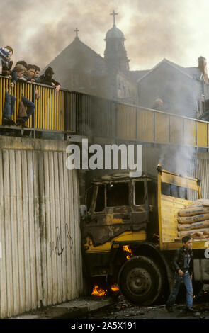 Irlande les troubles. Derry Londonderry a détourné un camion incendié par de jeunes fauteurs de troubles et utilisé comme barricade. 1980s. L'église derrière le camion en feu est l'église catholique romaine de long Tower, Lecky Road Flyover. HOMER SYKES Banque D'Images