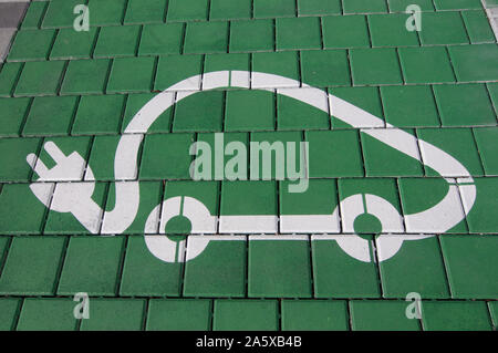 Close up photo d'une station de recharge de véhicules électriques symbole sur un fond vert, capturé à Lugano (Tessin) - Suisse Banque D'Images