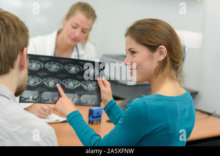 Les jeunes femmes l'examen des radiographies du cerveau avec mari Banque D'Images