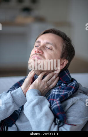 Homme malade wearing scarf tandis qu'une sensation de malaise et de froid Banque D'Images