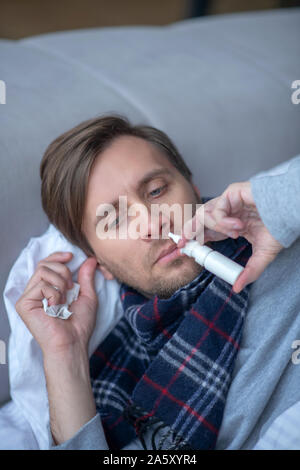 Vue de dessus de l'homme épuisé malades à l'aide de spray nasal Banque D'Images