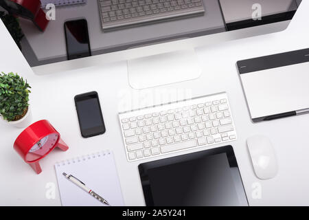 Vue supérieure moniteur ordinateur de bureau écran retina, souris, clavier, téléphone portable, tablette et écran vide sur le tableau blanc Banque D'Images