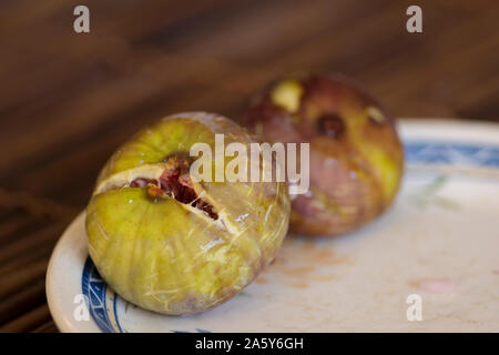 Vue rapprochée de figues commun mûrs (Ficus carica) fruits, servi dans une assiette blanche et bleue Banque D'Images