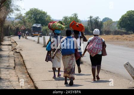 Les femmes personnes transportant de lourdes charges portant des tenues traditionnelles sur le passage de la frontière entre la Zambie et le Zimbabwe Afrique Banque D'Images