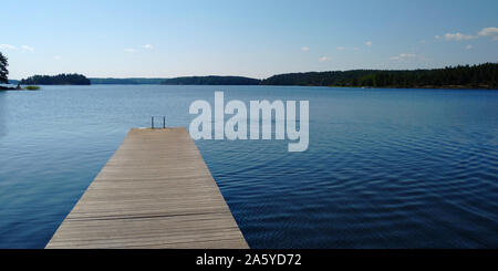 Longue jetée en bois et beau lac Saimaa, sur la Finlande et chaud jour d'été sans vent. Banque D'Images