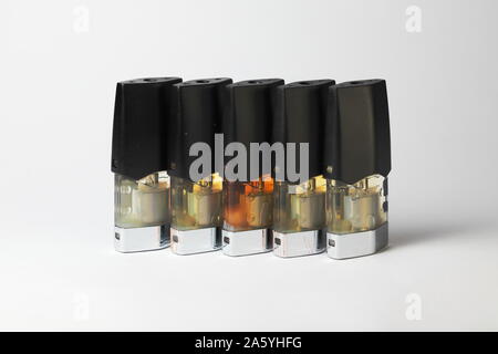 E-vape jus pods de remplissage avec des liquides de différentes nuances de jaune, orange isolé sur fond blanc close up Banque D'Images