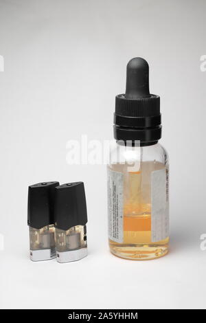 E-vape Jus remplissage avec avec une bouteille d'e-liquide orange isolé, Close up fond blanc Banque D'Images