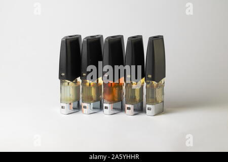 E-vape jus pods de remplissage avec des liquides de différentes nuances de jaune, orange isolé sur fond blanc close up Banque D'Images