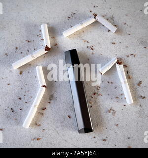 Vape unique type stylo cigarette électronique comme alternative de fumer des cigarettes et de tabac épars sur fond texturé blanc isolé Banque D'Images