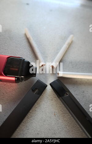 Vape 3 cigarette électronique et 3 cigarettes en étoile sur un fond texturé Blanc close up Banque D'Images