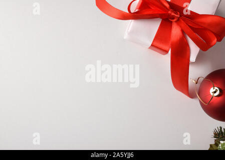 Cadeaux de Noël emballés avec du papier blanc et rouge sur blanc bow table avec boule de noël rouge. Composition horizontale. Vue d'en haut. Banque D'Images