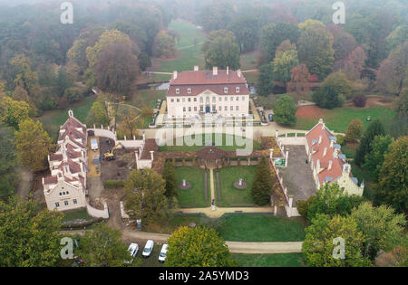 Cottbus, Allemagne. 23 Oct, 2019. À la lumière brouillard sur le Branitz en jardin des vous pouvez voir le château (M) et l'Cavalierhaus (l) (vue aérienne avec un drone). Depuis le début de 2019, le Cavalierhaus à Branitz château a été entièrement rénové. En plus de la toiture, la façade et la décoration du bâtiment, tout l'intérieur de l'immeuble néo-gothique devrait être rénové d'ici le printemps 2020. Crédit : Patrick Pleul/dpa-Zentralbild/ZB/dpa/Alamy Live News Banque D'Images