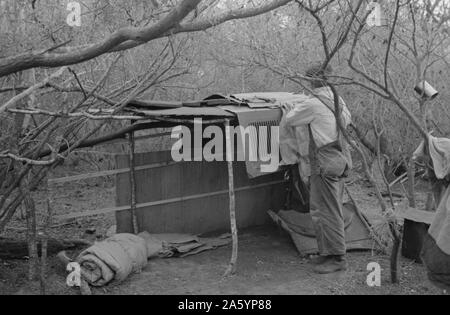Travailleur migrant blanc vivant au camp avec deux autres hommes, travaillant sur lean-to qui est d'être son coucher. Près de Harlingen, Texas par Russell Lee, 1903-1986, en date du 19390101. Banque D'Images