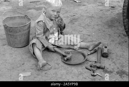 Enfant de travailleur migrant blanc jouant avec outils automobile près de Harlingen, Texas par Russell Lee, 1903-1986, en date du 19390101. Banque D'Images