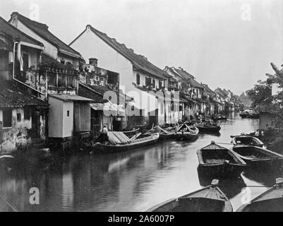 Impression photographique montrant les petits bateaux sur le canal du village dans l'île de Java en Indonésie. Datée 1890 Banque D'Images