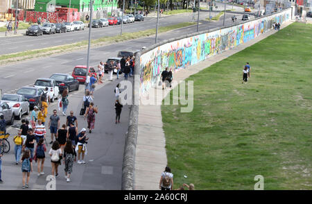 Berlin, Allemagne. Août 13, 2019. Les gens à pied et se tenir sur les deux côtés de la plus longue partie restante du mur de Berlin, l'East Side Gallery. De nombreuses couronnes étaient prévues dans la capitale à l'occasion de la construction du mur de Berlin il y a 58 ans. Credit : Wolfgang Kumm/dpa/Alamy Live News Banque D'Images