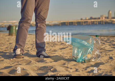 L'élève conscient est la marche avec sac à déchets le long d'une rive de la rivière sale et le nettoyage de la corbeille. Les gens et l'écologie. La pollution de la rivière. Volunte Banque D'Images