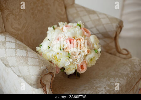 Belle fleur mauve rose beige rose roses, orchidées, chrysanthèmes et hortensias et eustomasbouquet mixte blanc sur le canapé marron. Banque D'Images